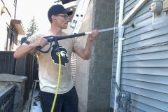 Technician pressure washing vinyl siding – Burnaby home