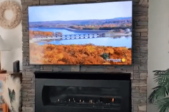 Wall-mounted TV installation above modern fireplace in Burnaby